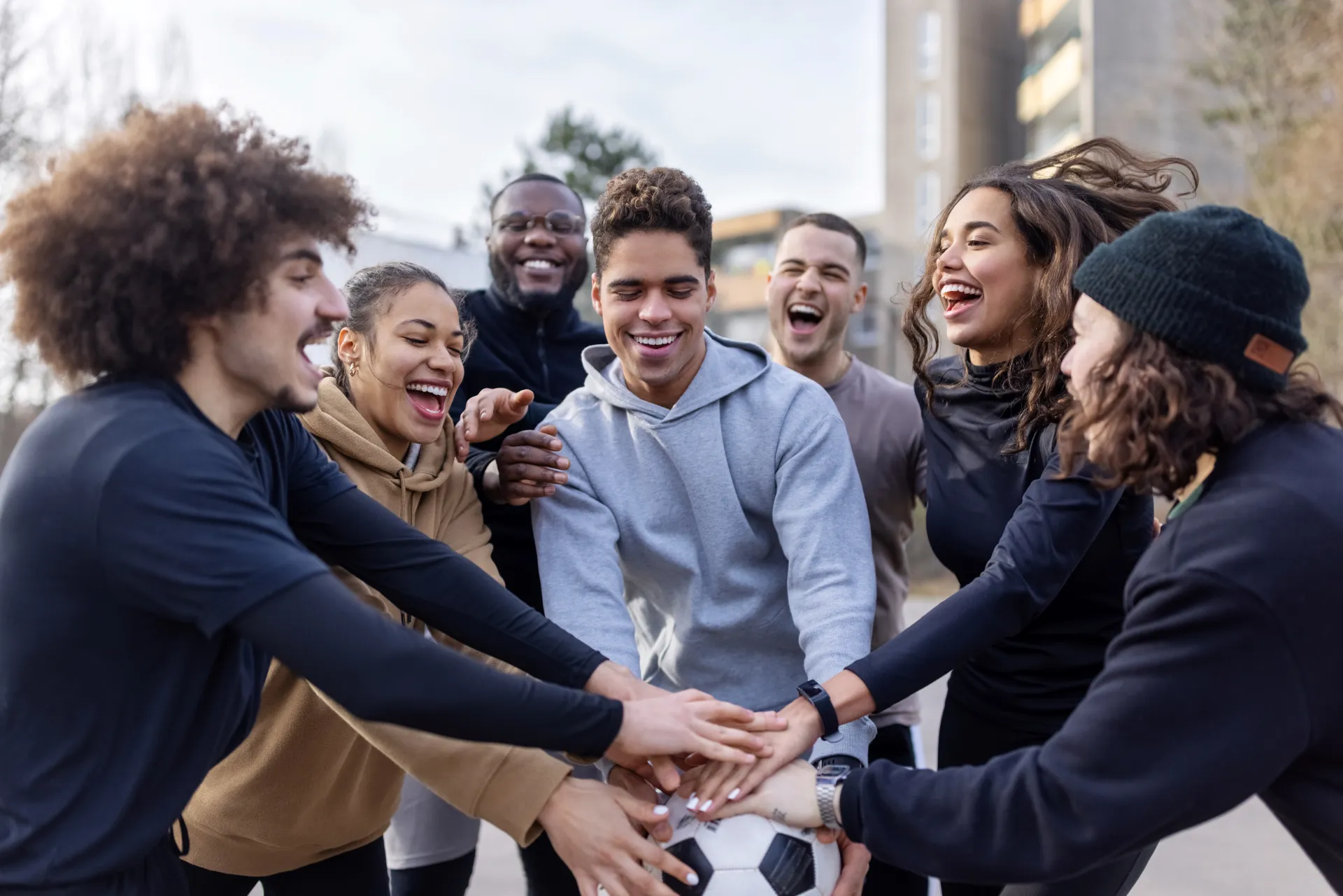 JJ_Photo_Happy-soccer-team-with-their-hands-stacked-in-football-court_GettyImages_1391375325.jpg
